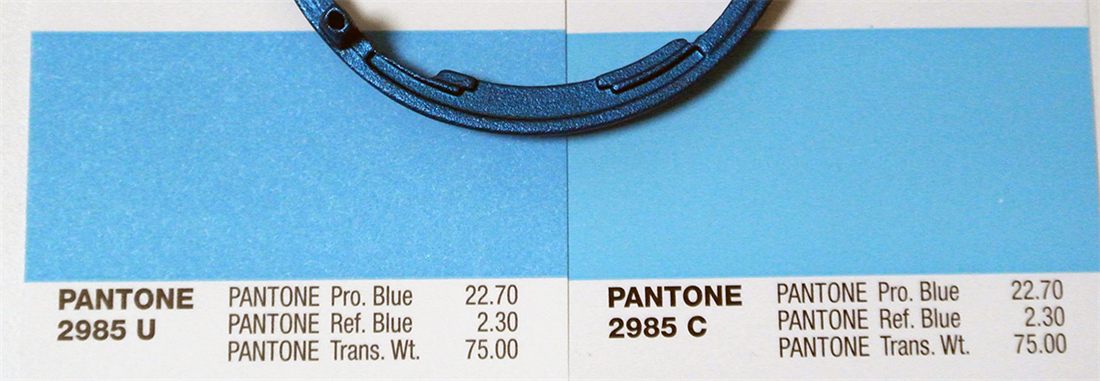 Molded blue part compared against a Pantone colour reference card
