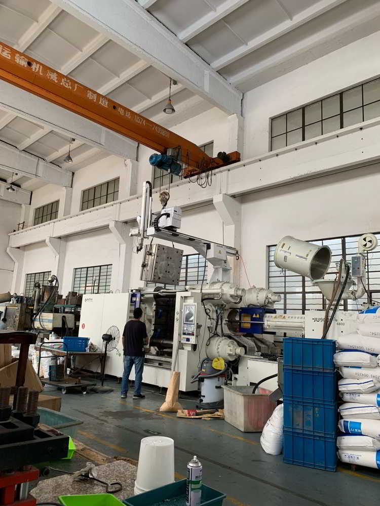 Injection molding machine on a factory floor during a production run